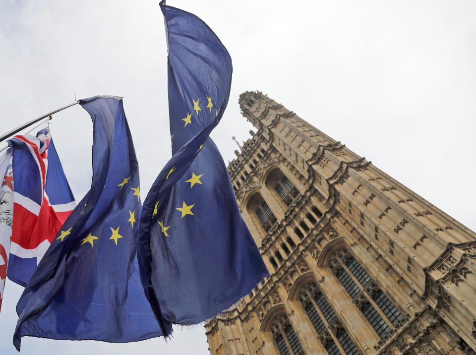 Flags of Anti Brexit protestors fly in front of parliament in London, Wednesday, Oct. 23, 2019. Britain's government is waiting for the EU's response to its request for an extension to the Brexit deadline. (AP Photo/Frank Augstein)