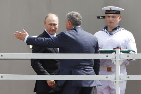 Russian President Vladimir Putin (L) and Rosneft Chief Executive Igor Sechin (C) take part in a ceremony launching the construction of new vessels at the Zvezda shipyard in the far eastern town of Bolshoy Kamen, Russia September 8, 2017. REUTERS/Sergei Karpukhin/Files