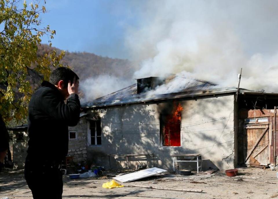 Un hombre se lamenta viendo una casa incendiada en la aldea de Cherektar, en la región de Nagorno-Karabaj. La zona estaba bajo control armenio, pero fue entregada a Azerbaiyán tras el acuerdo de alto el fuego. Antes de partir, muchos armenios quemaron sus domicilios. (Foto: Stringer / Reuters).