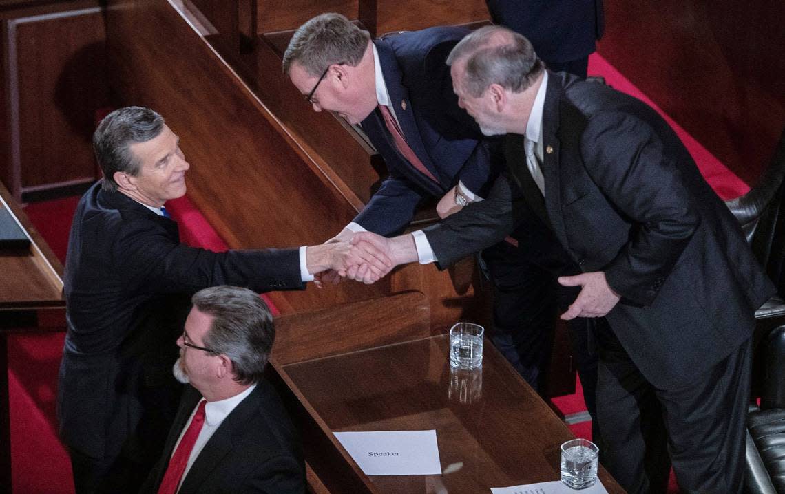 Gov. Roy Cooper, left, shakes hands with House Speaker Tim Moore, center and Senate Leader Phil Berger prior to Cooper’s biennial State of the State address to a joint session of the General Assembly at the Legislative Building Monday evening, Feb. 26, 2019.