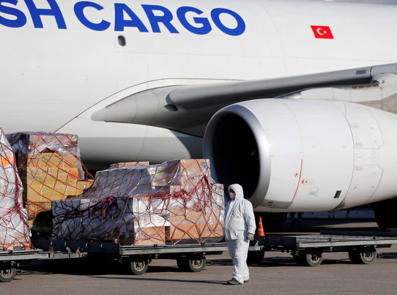 A worker unloads a shipment of medical supplies from Turkey intended to combat the spread of the coronavirus disease (COVID-19), at Almaty International Airport