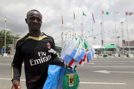 A man sells souvenirs with the image of President-elect Muhammadu Buhari and the flags of his party the All Progressives Congress, before his inauguration ceremony on Friday, at the Eagle Square in Abuja, Nigeria May 27, 2015. REUTERS/Afolabi Sotunde