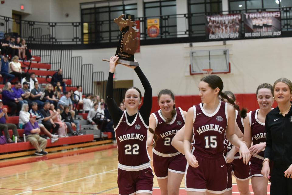 Morenci senior Leah Rorick walks off the floor with the Division 4 regional championship trophy after beating Allen Park Inter-City Baptist at Whitmore Lake.