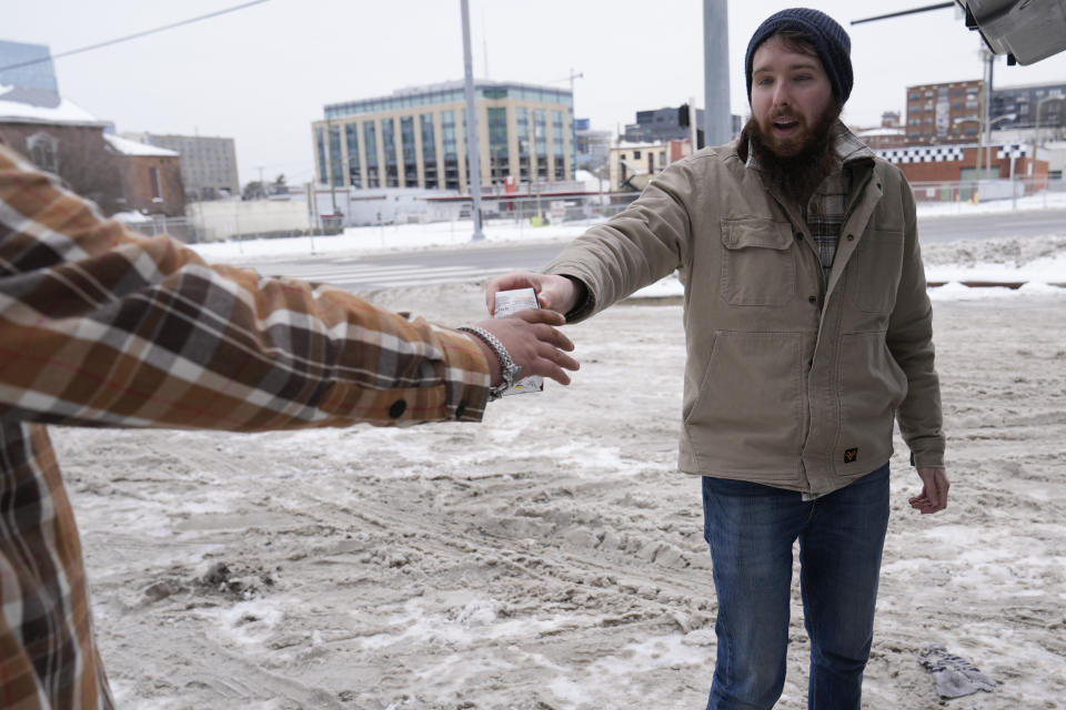 Will Compton hands out food and winter supplies to the homeless Thursday, Jan. 18, 2024, in Nashville, Tenn. Compton is a resource specialist for the homeless outreach organization Open Table Nashville. A snowstorm blanketed the area with up to eight inches of snow and frigid temperatures. (AP Photo/George Walker IV)