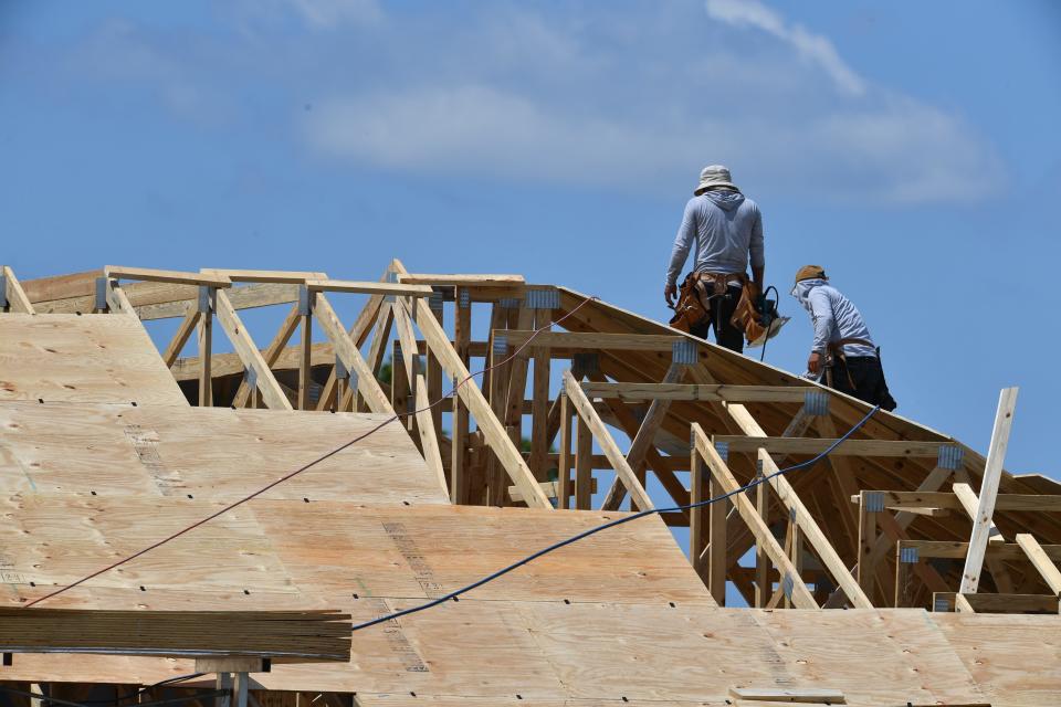 Local home builders are starting to see a pick up in business after a 10% drop in new home permits last month. Construction workers install plywood sheets on the roof of a new home in Lakehouse Cove at Waterside in Lakewood Ranch.