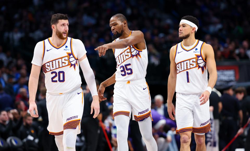 Phoenix Suns forward Kevin Durant (35) and Phoenix Suns guard Devin Booker (1) and Phoenix Suns center Jusuf Nurkic (20) talk during the third quarter against the Dallas Mavericks at American Airlines Center in Dallas, Texas on Jan. 24, 2024.