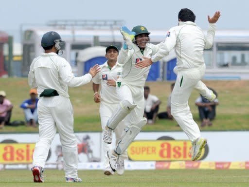 Pakistan's Saeed Ajmal (right) celebrates with wicketkeeper Adnan Akmal (2nd right) after the dismissal of Sri Lanka's Tharanga Paranavitana during the first day of the opening Test match at the Galle International Stadium. Tillakaratne Dilshan and Kumar Sangakkara have hammered centuries as Sri Lanka walloped Pakistan on the opening day of the first cricket Test in Galle