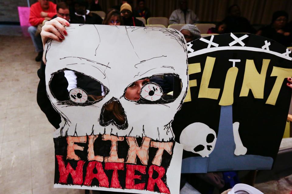 Flint resident Melissa Mays holds her signs up before a forum discussing growing health concerns over drinking the city's water being raised by Flint residents on Wednesday January 21, 2015 at the Flint City Hall dome. Residents have been in an uproar following a letter that detailed the city was in violation of the Safe Drinking Water Act due to high levels of trihalomethane (TTHM) in drinking water samples last year. Flint stopped getting water from Detroit and began using the Flint River as a temporary source of drinking water in April 2014 until a new pipeline is built. 