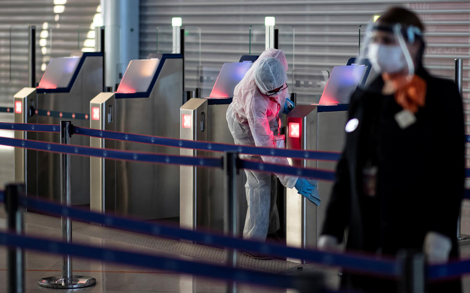 Un trabajador desinfecta una puerta de acceso a la zona de embarque del Aeropuerto de París-Charles de Gaulle (Francia). (Foto: Ian Langsdon / Reuters).