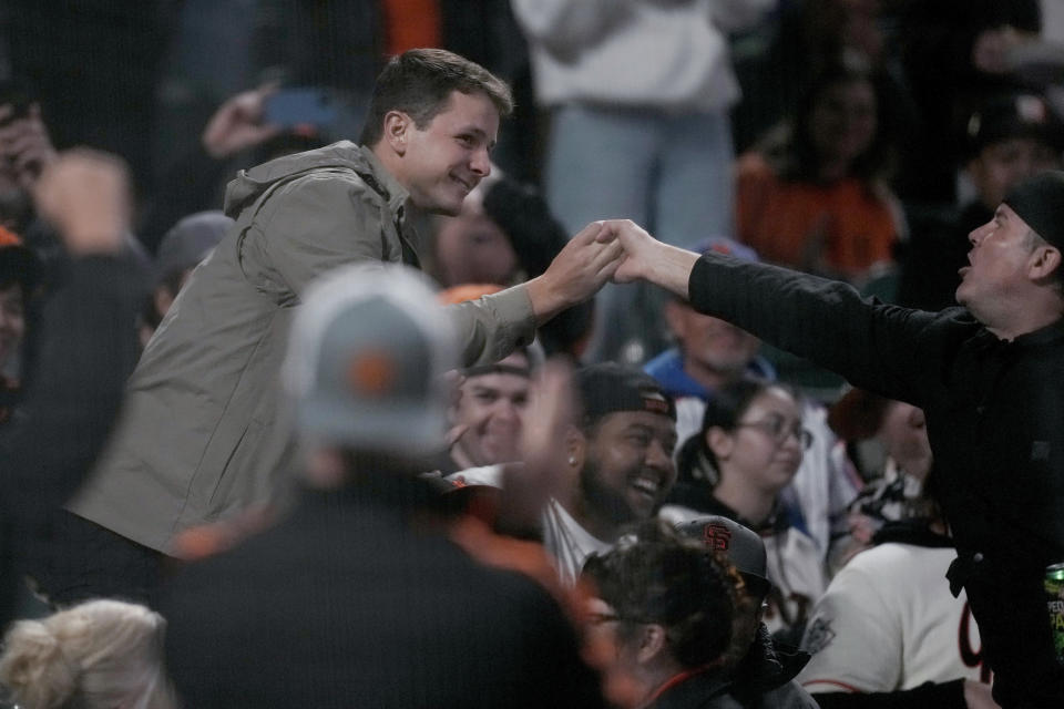 San Francisco 49ers quarterback Brock Purdy greets fans during the fourth inning of a baseball game between the San Francisco Giants and the New York Mets in San Francisco, Friday, April 21, 2023. (AP Photo/Jeff Chiu)