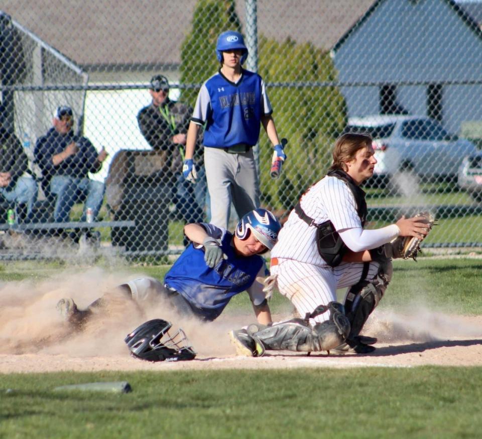 Inland Lakes' Andrew Kolly (left) scores a run before Cheboygan catcher Dylan Balazovic (right) can apply a tag during a matchup on Monday.