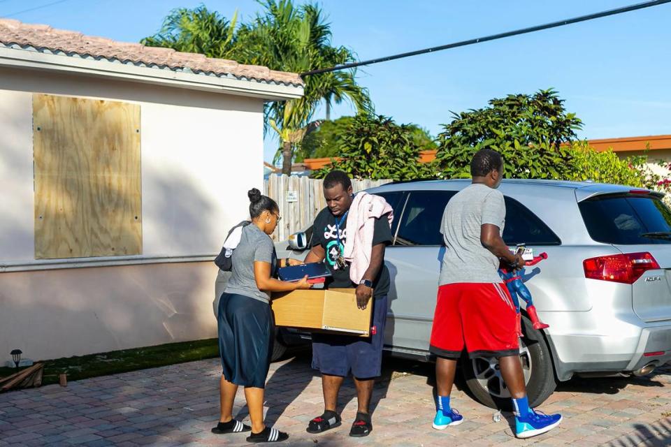 Christopher Fernández, center, helps gather items from a burnt home located at 3621 NW 18 Terrace in Miami, on Thursday, January 2, 2020. On Monday, the house caught fire, killing the four children, who lived in the home with their grandmother. Fernández is the children’s uncle.