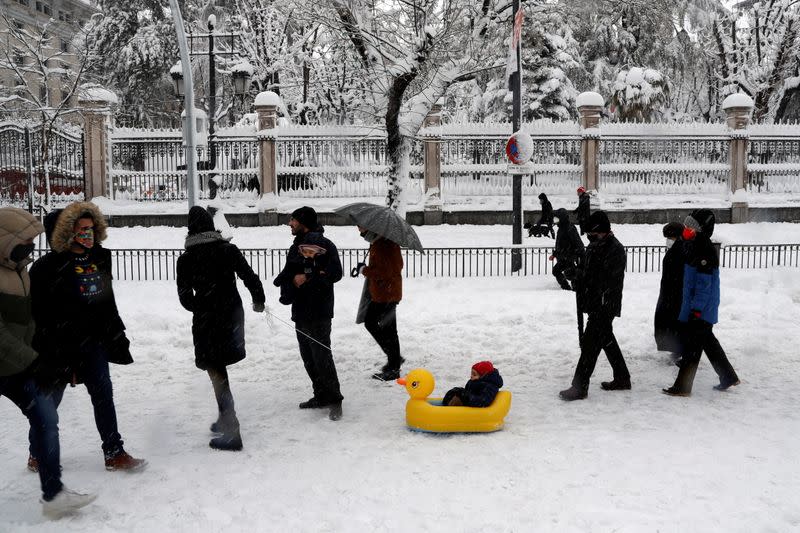 People walk downtown during a heavy snowfall in Madrid