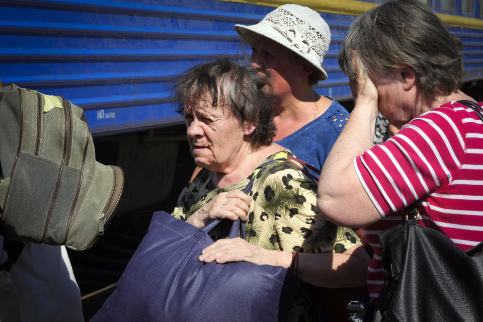 People walk towards an evacuation train in Pokrovsk railway station, eastern Ukraine, Saturday, June 11, 2022. (AP Photo/Efrem Lukatsky)