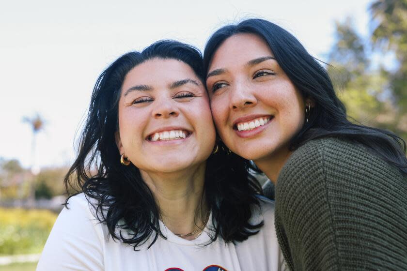 Los Angeles, CA - April 16: Friends Mary Delgado and Emmely Avila, left and right, pose for a portrait together where they first met at Echo Park Lake on Tuesday, April 16, 2024 in Los Angeles, CA. Emmely is the founder and organizer of the Los Angeles Friends Club, a group designed to help people connect and she met her best friend Mary through the club. (Dania Maxwell / Los Angeles Times)