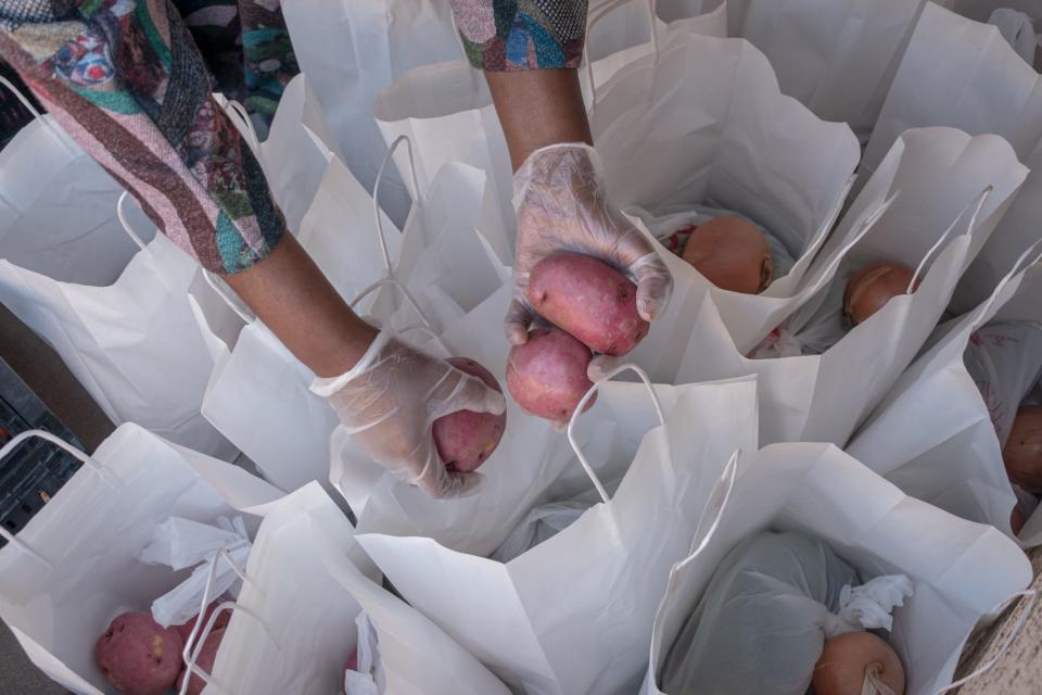 Volunteers help pack the grocery bags for families in need on Nov. 13, 2021, in Phoenix.