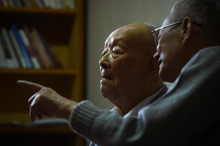 Zhou Youguang (L), commonly known as the "father of Pinyin", talks to his son Zhou Xiaoping at his home in Beijing on January 11, 2015 (AFP Photo/Wang Zhao)