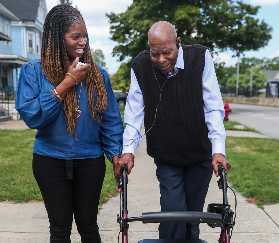 Myzette Howell spots her father Percy Howell as they take a walk around their neighborhood in Buffalo. Myzette caregives for her parents who have Alzheimer's disease.