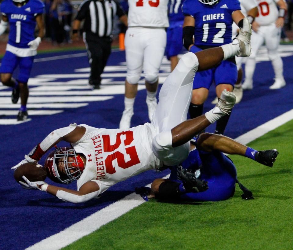 Sweetwater running back Korda Moore (left) reaches over the goal line for a 2-point conversion before Lake View defensive back Adrian Flores (right) can make the tackle at San Angelo Stadium on Sept. 1, 2023.