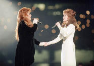 FILE - Wynonna Judd, left, and her mother, Naomi Judd, of The Judds, perform during the halftime show at Super Bowl XXVIII in Atlanta on Jan. 30, 1994. Naomi Judd, the Kentucky-born matriarch of the Grammy-winning duo The Judds and mother of Wynonna and Ashley Judd, has died, her family announced Saturday, April 30, 2022. She was 76. (AP Photo/Eric Draper, File)