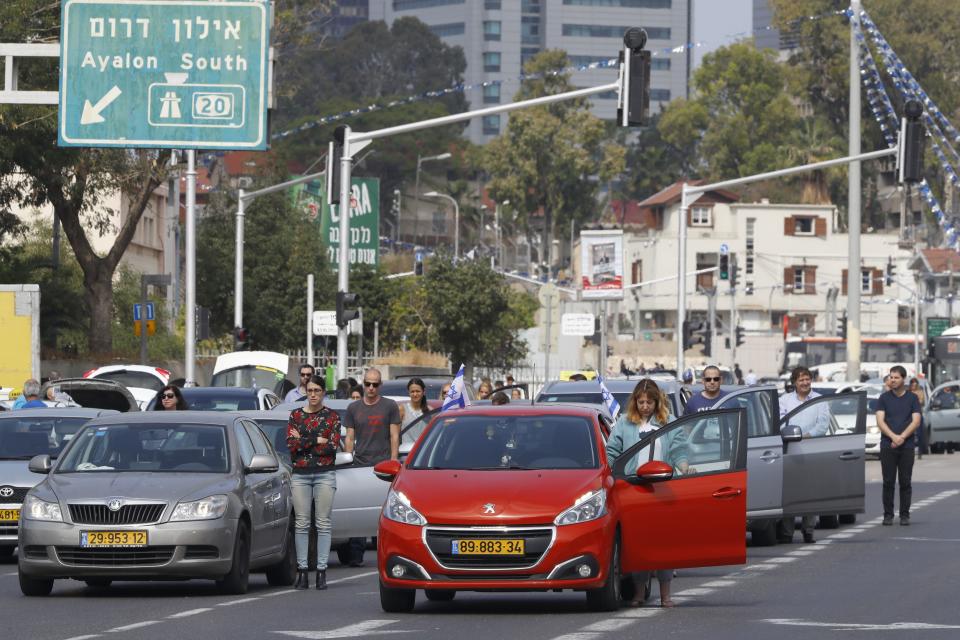 Drivers stop and stand in silence on a street in Tel Aviv.