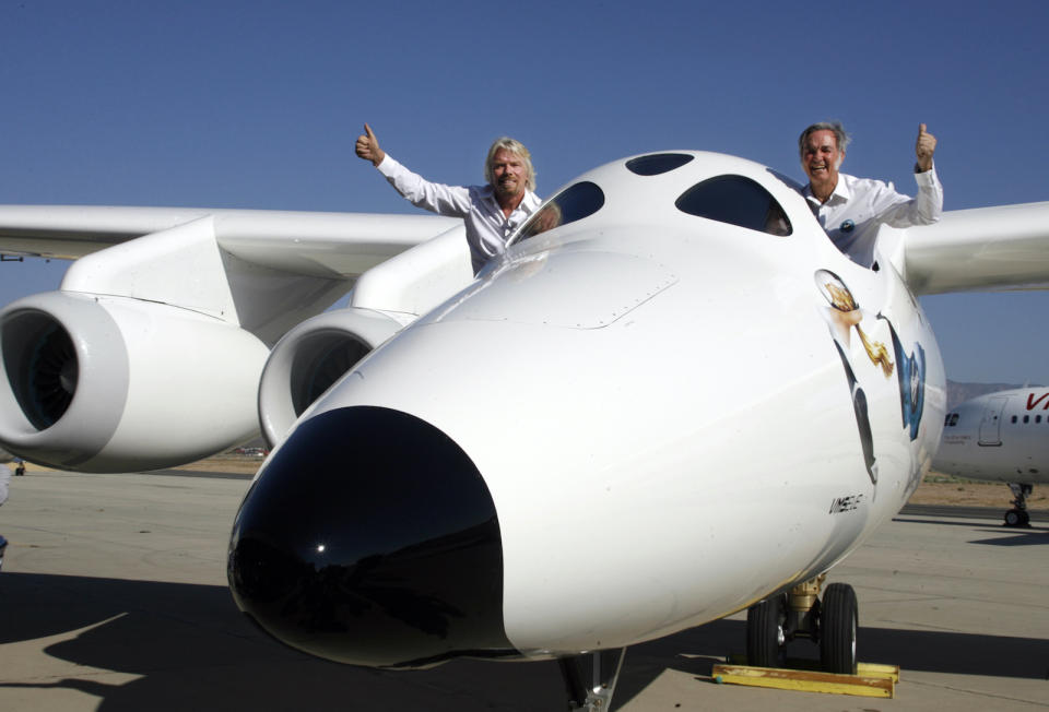 Virgin Group's Founder billionaire Richard Branson (L) and Burt Rutan, president of Scaled Composites, wave from the window of Virgin Galactic's mothership WhiteKnightTwo during its public roll-out in Mojave, California July 28, 2008. The twin fuselage aircraft WhiteKnightTwo will carry SpaceShipTwo to launch commercial passengers into space.  REUTERS/Fred Prouser  (UNITED STATES) - GM1E47T052201