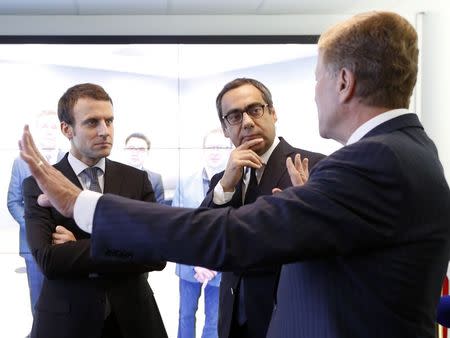 French Economy Minister Emmanuel Macron (L) and Robert Vassoyan (C), chief executive of Cisco France, listen to Cisco Executive Chairman John Chambers (R) during a visit at the Cisco France headquarters in Issy-Les-Moulineaux, near Paris, France, October 8, 2015. REUTERS/Jacky Naegelen