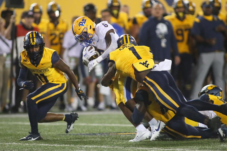 Pittsburgh Panthers Rodney Hammond Jr. (6) gets wrapped up for a tackle by West Virginia Mountaineers Beanie Bishop Jr. (11) and Lee Kpogba (1) during the first half at Milan Puskar Stadium in Morgantown, WV on September 16, 2023.