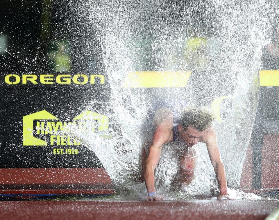 Portland's Eliason Kabasenche throws up a wall of water as he falls in the men's 3,000 meter steeplechase at the Oregon Relays at Hayward Field Friday April 22, 2022.
