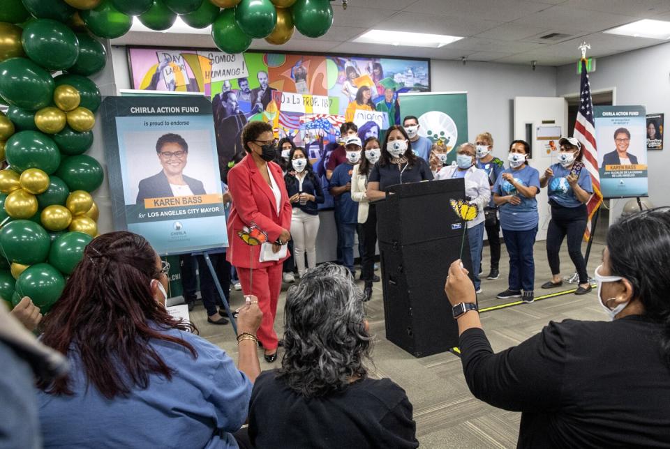 A woman is surrounded by supporters and balloons