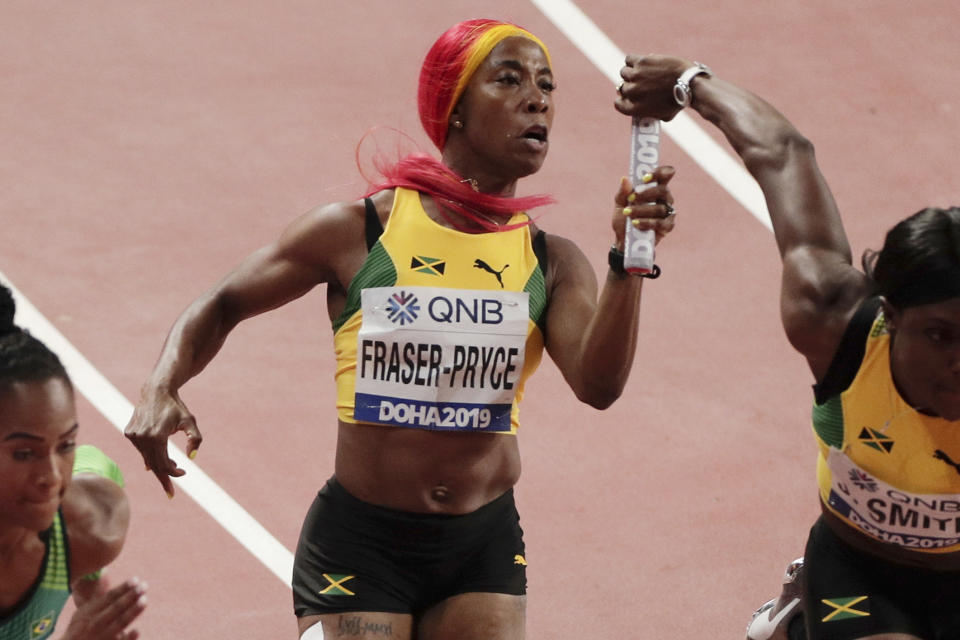 ARCHIVO - En esta foto del 4 de octubre de 2019, Shelly-Ann Fraser-Pryce (centro) entrega el testigo durante el relevo 4x100 de Jamaica en el Mundial de atletismo en Doha, Qatar. (AP Foto/Nariman El-Mofty, File)