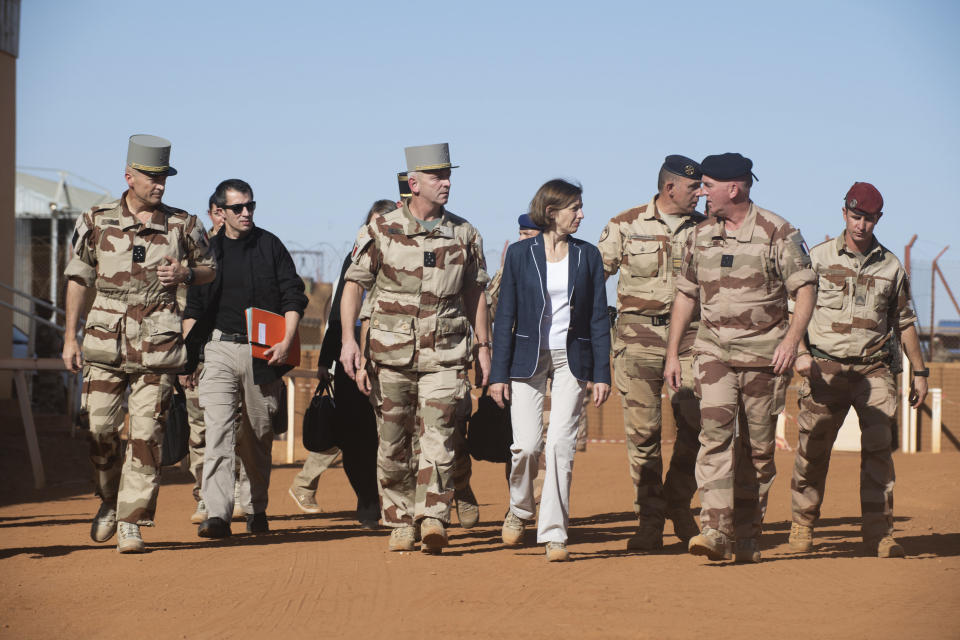 In this photo provided by the French Defense Communication and Audiovisual Department (ECPAD) French Defense Minister Florence Parly, center, and French Army Chief of Staff Gen. Francois Lecointre, center left, arrive in Gao, Mali, Wednesday, Nov. 27, 2019 to pay homage to the 13 French soldiers killed after a helicopter collision while fighting Islamic State group-linked extremists. It was France’s highest military death toll in nearly four decades. (Thomas Paudeleux/ECPAD via AP)