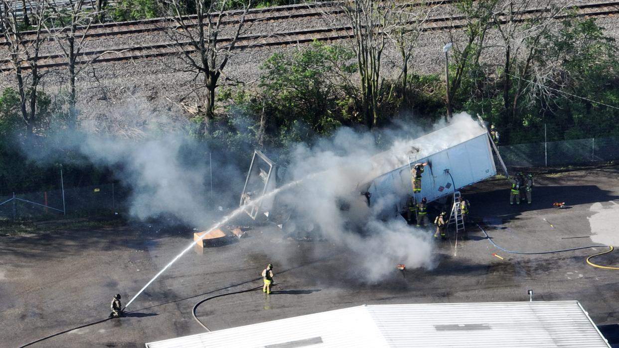 Firefighters cut a hole in a burning truck that reportly contains litium ion batteries. The fire is at a business in the 1600 block of McKinley Ave. Thursday morning April 18, 2024.