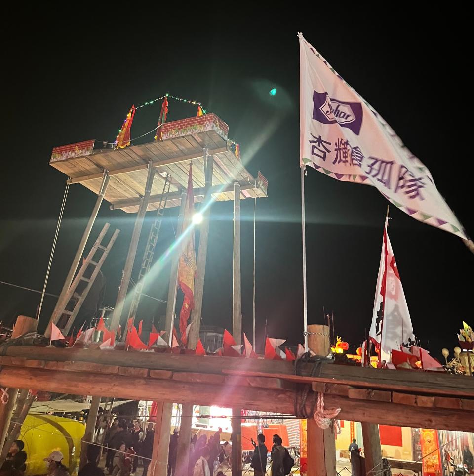 中國龍海搶孤使用刨光的孤柱，選手從地面攀爬將近13公尺高的孤柱，爬到柱頂時，再用「倒翻棚」技法爬上孤棚。(照片提供：杏輝藥品)