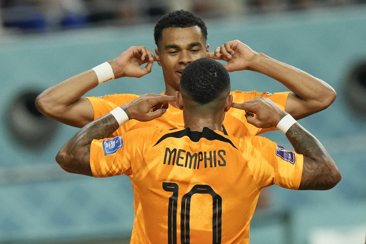 Memphis Depay of the Netherlands, back to the camera, celebrates after scoring his side's first goal during the World Cup round of 16 soccer match between the Netherlands and the United States, at the Khalifa International Stadium in Doha, Qatar, Saturday, Dec. 3, 2022. (AP Photo/Francisco Seco)