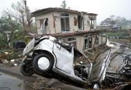 Destroyed house and vehicle are seen following a strong wind in Ichihara, Chiba, near Tokyo Saturday, Oct. 12, 2019. Tokyo and surrounding areas braced for a powerful typhoon forecast as the worst in six decades, with streets and trains stations unusually quiet Saturday as rain poured over the city. (Katsuya Miyagawa/Kyodo News via AP)