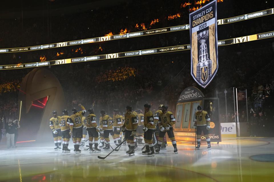 Members of the Vegas Golden Knights watch as a Stanley Cup championship banner is raised during a ceremony before an NHL hockey game against the Seattle Kraken, Tuesday, Oct. 10, 2023, in Las Vegas. (AP Photo/John Locher)