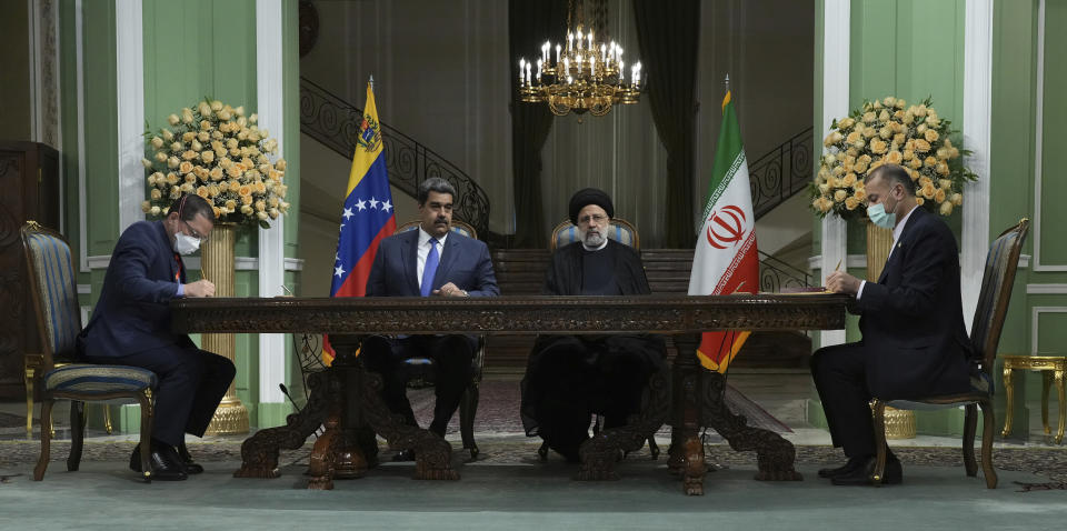 Iranian Foreign Minister Hossein Amirabdollahian, right, and his Venezuelan Foreign Minister Jorge Arreaza, left, sign their countries bilateral cooperation agreement as Iranian President Ebrahim Raisi, second right, and his Venezuelan President Nicolas Maduro look on, at the Saadabad Palace in Tehran, Iran, Saturday, June 11, 2022. (AP Photo/Vahid Salemi)