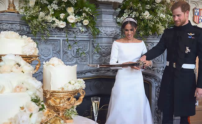 Harry and Meghan cutting their wedding cake with a sword