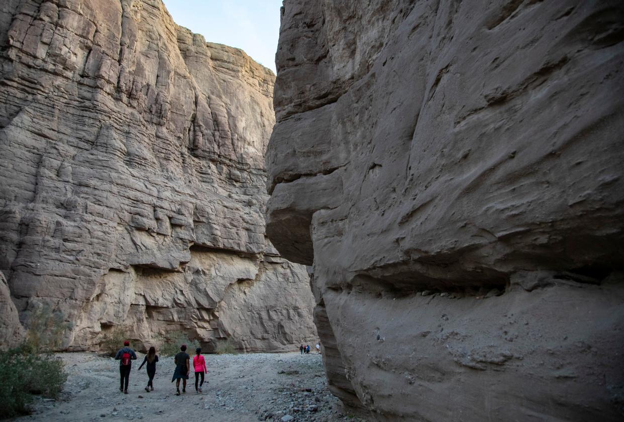Hikers return to their vehicles on Painted Canyon trail in Mecca, Calif., Wednesday, Dec. 28, 2022. 