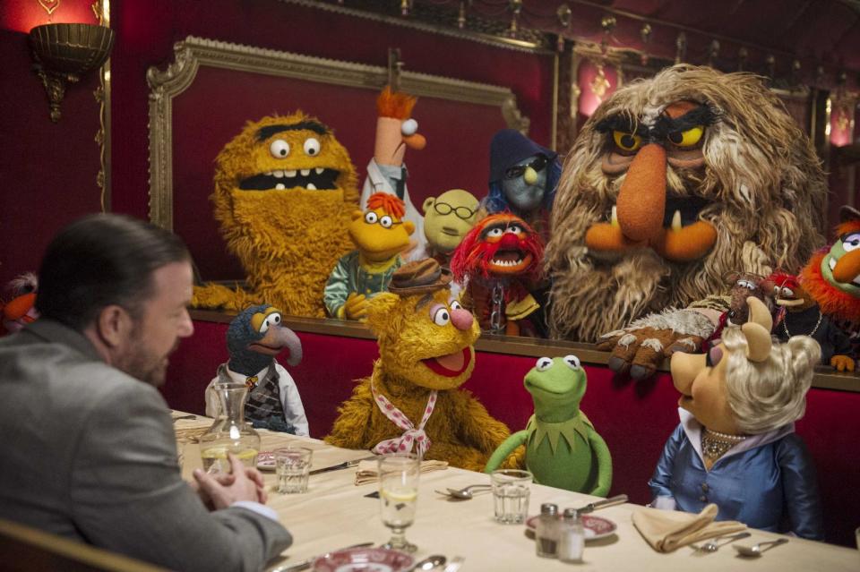 This image released by Disney shows Ricky Gervais, left, with the muppets in a scene from "Muppets Most Wanted." (AP Photo/Disney Enterprises, Inc., Jay Maidment)