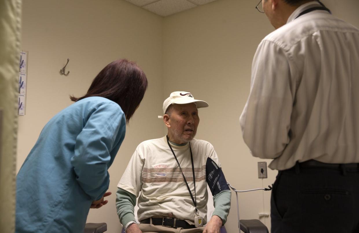 <span class="caption">The nonprofit International Community Health Services medical clinic in Seattle provides care for uninsured people. </span> <span class="attribution"><a class="link " href="https://www.gettyimages.com/detail/news-photo/bing-hong-liu-talks-to-to-dr-alan-chun-through-an-news-photo/1207855461?adppopup=true" rel="nofollow noopener" target="_blank" data-ylk="slk:Photo by Karen Ducey/Getty Images;elm:context_link;itc:0;sec:content-canvas">Photo by Karen Ducey/Getty Images</a></span>