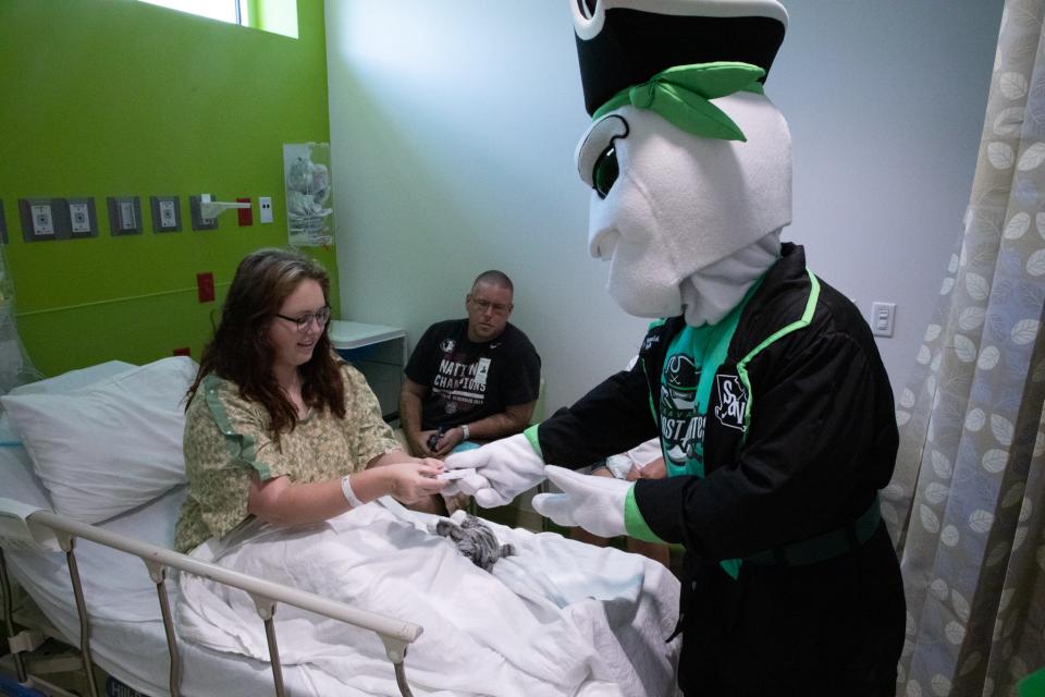 Davy hands team merchandise to patient Cassidy Buckner on Aug. 17, 2022.