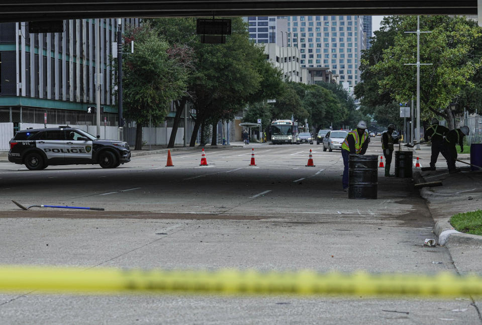 Workers clean at the scene of a car accident, Saturday, Nov. 11, 2023, in downtown Houston, Texas. An early morning accident at the location left six people dead including former University of Houston and NFL football player D.J. Hayden. /Houston Chronicle via AP)/Houston Chronicle via AP)