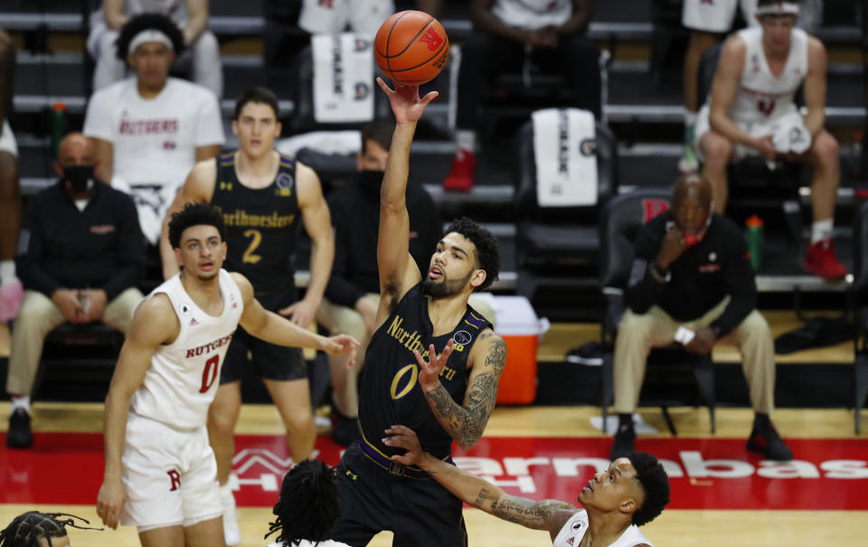 Northwestern's Boo Buie (0) shoots over Rutgers defenders during the first half of an NCAA college basketball game in Piscataway, N.J., Saturday, Feb. 13, 2021. (AP Photo/Noah K. Murray)