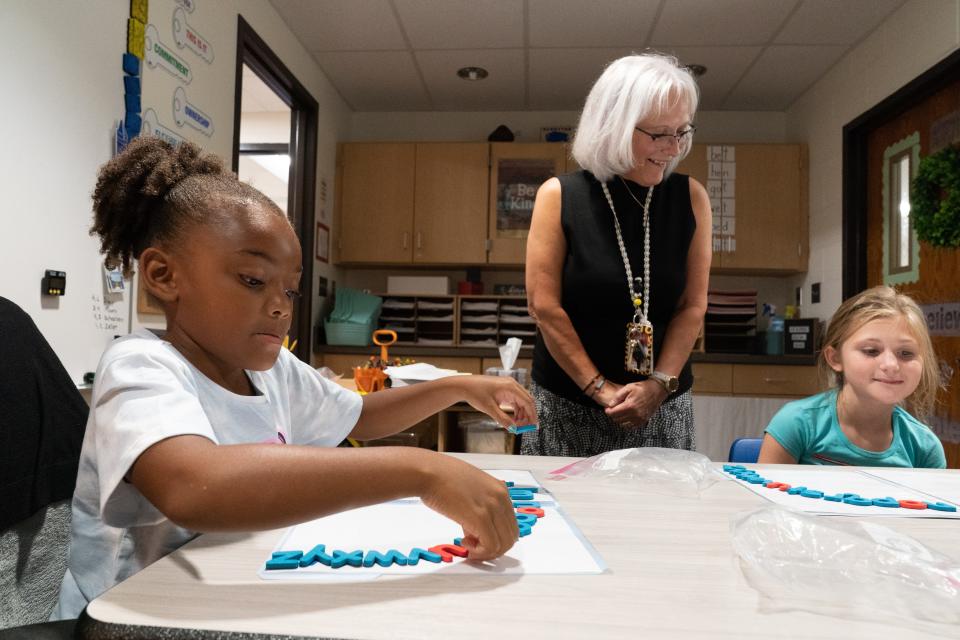 Berryton Elementary first-graders Journee Freeman, left, and Stevie Stinebaugh complete their alphabet arcs as Karen Brantingham watches over the two Friday morning.