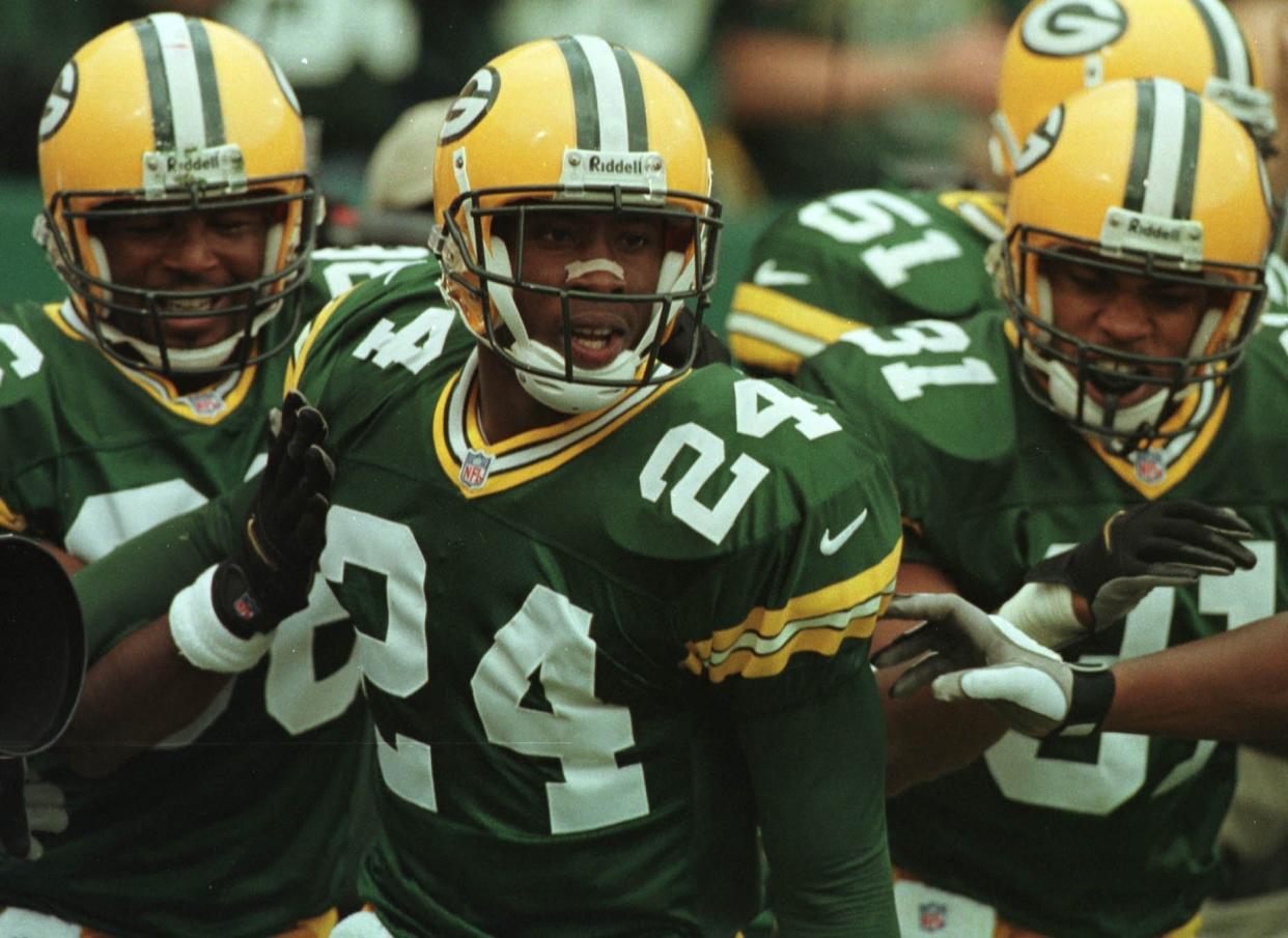 Green Bay Packers cornerback Antuan Edwards is congratulated by teammates after scoring touchdown on an intercepted pass.