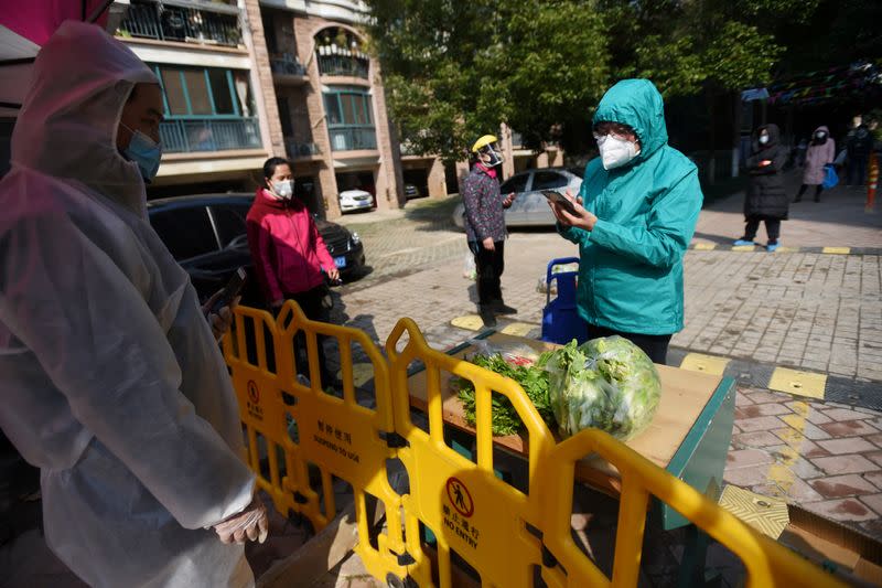 FILE PHOTO: Resident uses a mobile phone to pay for vegetables purchased through group orders at a collection point set up at the entrance of a residential compound in Wuhan