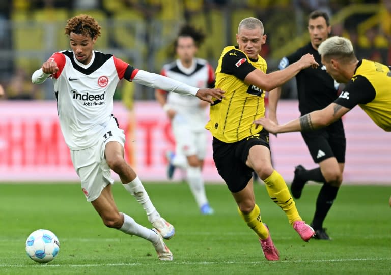 Eintracht Frankfurt forward Hugo Ekitike (L) gets away from the Borussia Dortmund defence (INA FASSBENDER)