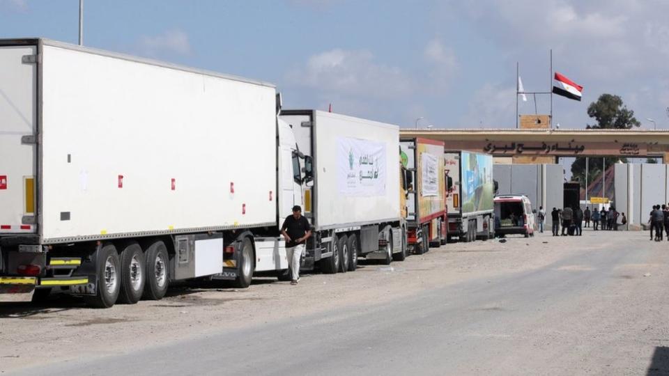 Trucks of a humanitarian aid convoy are parked outside border gate between in Rafah, Egypt, 19 October 2023